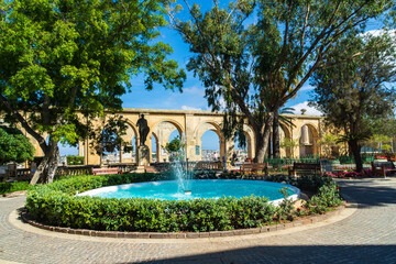 The fountain and terraced arches at the Upper Barrakka Garden, a public garden in the city of Valletta, Malta. - obrazy, fototapety, plakaty
