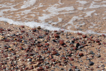 Sandy beach by the sea Arising from broken glass bottles Which was repeatedly hit by the waves until the sharp edges of the glass are gone