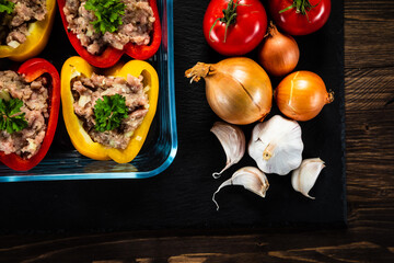 Uncooked stuffed pepper with meat on wooden table
