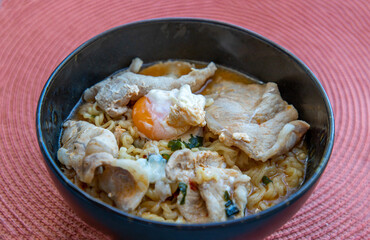 Boil egg noodles with pork, fried egg, vegetables and soups in bowl. Thai noodle soup, Selective focus.