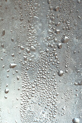 Frozen drops of condensation on a window, a sharp drop in temperature, sharply frozen drops of water on glass in winter, extremely cold low air temperatures