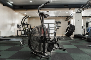 Fototapeta na wymiar Functional cross equipment. Interior of modern gym. Air bike in cross fit gym