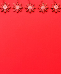 Obraz na płótnie Canvas White and red wooden Christmas tree decorations on a red background with place for text.