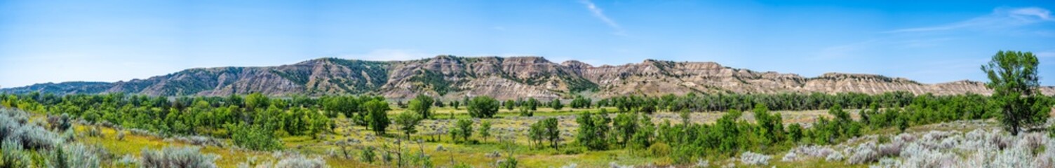Fototapeta na wymiar panoramic view of great plains with a backdrop of the badlands rising in the distance at Theodore Roosevelt National Park, North Dakota, USA