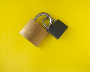 Padlocks. Two locks are interlocked. Flatlay on yellow background. Concept.