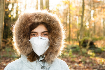 Eine Teenagerin trägt eine FFP2 Atemschutz Maske im Winter - obrazy, fototapety, plakaty