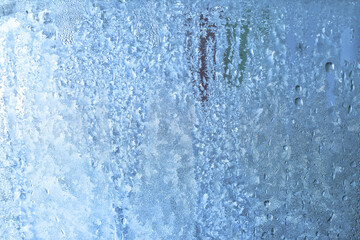 Fototapeta na wymiar Frozen drops of condensation on a window, a sharp drop in temperature, sharply frozen drops of water on glass in winter, extremely cold low air temperatures