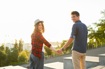 Fototapeta na wymiar Young couple of lovers hold hands at sunrise. Spending time together. Love concept
