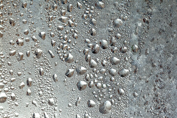 Frozen drops of condensation on a window, a sharp drop in temperature, sharply frozen drops of water on glass in winter, extremely cold low air temperatures