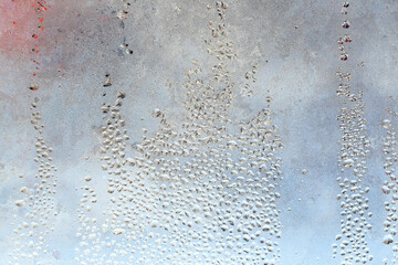 The texture of frozen drops of condensation on a transparent glass window. Water drops. Rain. Abstract texture background. A sharp cold snap, a frozen drop of water on the glass in winter