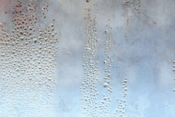 Frozen drops of condensation on a window, a sharp drop in temperature, sharply frozen drops of water on glass in winter, extremely cold low air temperatures
