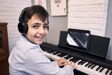 Child learning piano online lessons in quarantine . Coronavirus life style