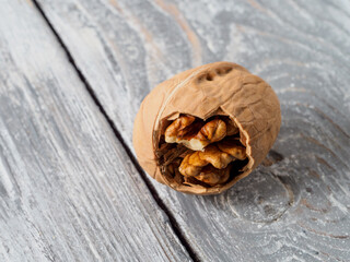 Walnut with shell on wooden background.
