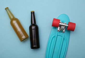 Youth concept. Beer bottles and skateboard on a blue background. Top view. Flat lay