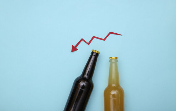 Beer bottles and a falling arrow on a blue background. Top view