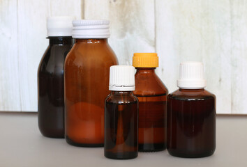 brown bottle with cough syrup on background