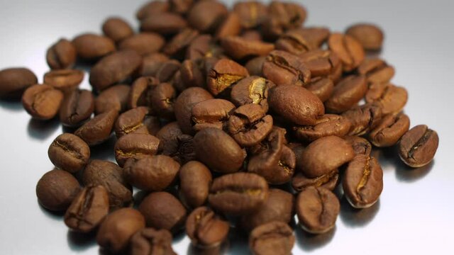 Roasted coffee beans rotate on white background. Freshness ingredient for prepare coffee.