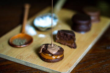 Uruguayan and Argentinian alfajor in dark scenery. Typical South American food. Chocolate cake with dulce de leche filling. Uruguay. Argentina