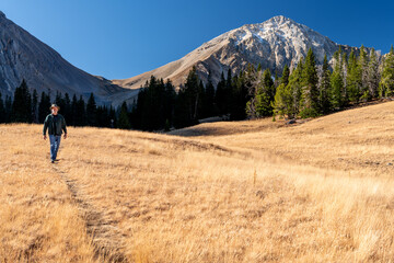 Fototapeta na wymiar Man follows a hiking trail through the mountains