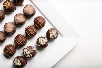 Obraz na płótnie Canvas variety of handmade gourmet chocolate truffle candy on a white plate