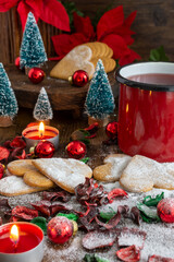 Close-up of gingerbread cookies with sugar, red mug and red Christmas decoration, selective focus, vertical
