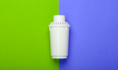 Filter element of water purifier on green purple background. Top view