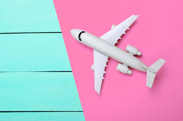 Airplane on a yellow, pink wooden background. Top view. Vacation, travel concept