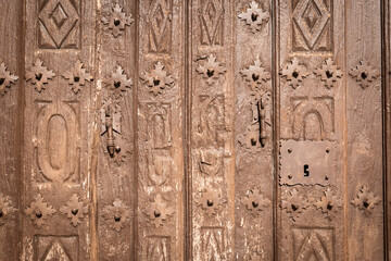 old brown wooden door with metallic ornaments	