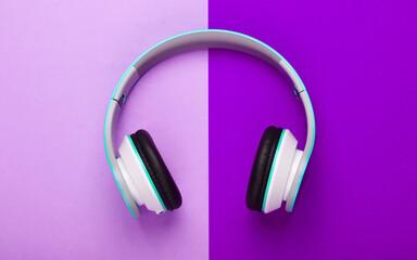 Stylish wireless stereo headphones on pink background. Music lover. Gadgets. Top view.