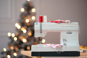 Christmas advertisement photo for atelier Sewing machine on the foreground, festive Christmas lights on the background