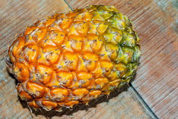 Fresh ripe summer fruit pineapple on wooden background.