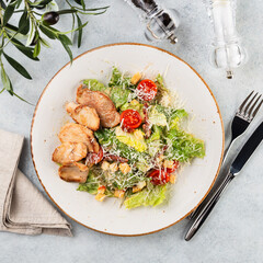Grilled chicken breast, fillet and fresh vegetable salad of lettuce and tomato. Chicken Caesar Salad. Top view