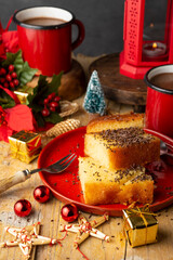 Top view of red cups with chocolate, lemon cake, candle with candle and Christmas decorations, with selective focus, vertical