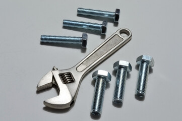 screw-nut of different sizes, bolts and adjustable spanner. White background.