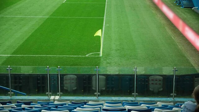 A yellow corner flag waving in the wind on a football or soccer field. View from the stadium tribune. Football match on a stadium. High quality 4k footage