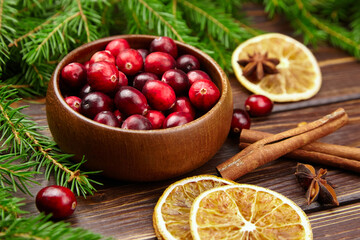 Cranberries fresh berries in wooden bowl on table with Christmas tree branches