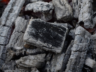 coals covered with ash in an extinct campfire