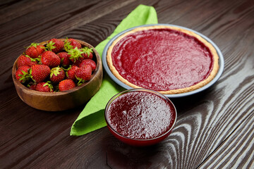 Strawberry tart with strawberry jam and fresh berries on wooden background