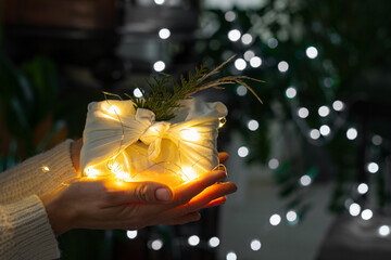 Christmas gift. Packaging in eco-friendly materials, furoshiki fabric. Bokeh, selective focus