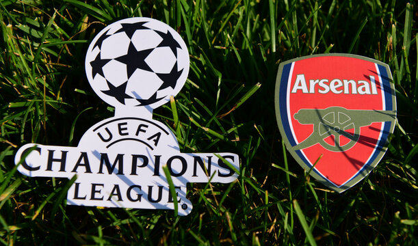 September 6, 2019 Istanbul, Turkey. The emblem of the English football club Arsenal London next to the logo of the Champions League on the green grass of the football field.