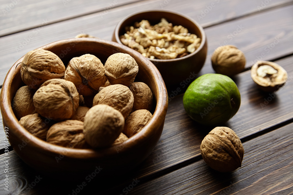 Wall mural walnuts in round bowl on wooden table