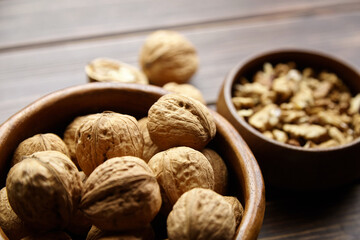 Walnut half and seeds and bowl on wooden table