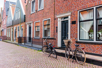 Fototapeta na wymiar Dutch village green houses facade and bicycle.