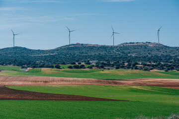 Agro field in Cuenca with green and brown colors Spain and windmills