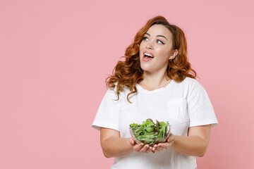 Excited amazed young redhead plus size body positive woman 20s wearing white casual t-shirt hold...
