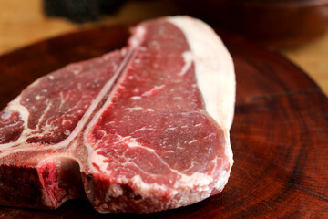 Raw T Bone. Preparing for the barbecue. In wooden background