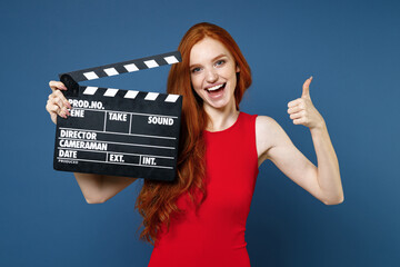 Funny cheerful young redhead woman 20s wearing bright red elegant evening dress standing hold...