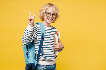 Cheerful little male teen boy 10s years old in striped sweatshirt eyeglasses backpack hold school...
