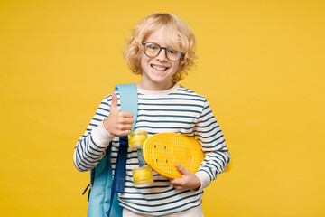 Smiling funny little male kid teen boy 10s years old in striped sweatshirt eyeglasses backpack hold...
