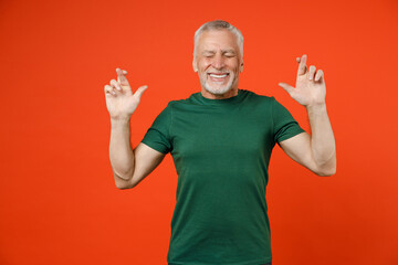 Funny elderly gray-haired mustache bearded man in basic green t-shirt waiting for special moment,...